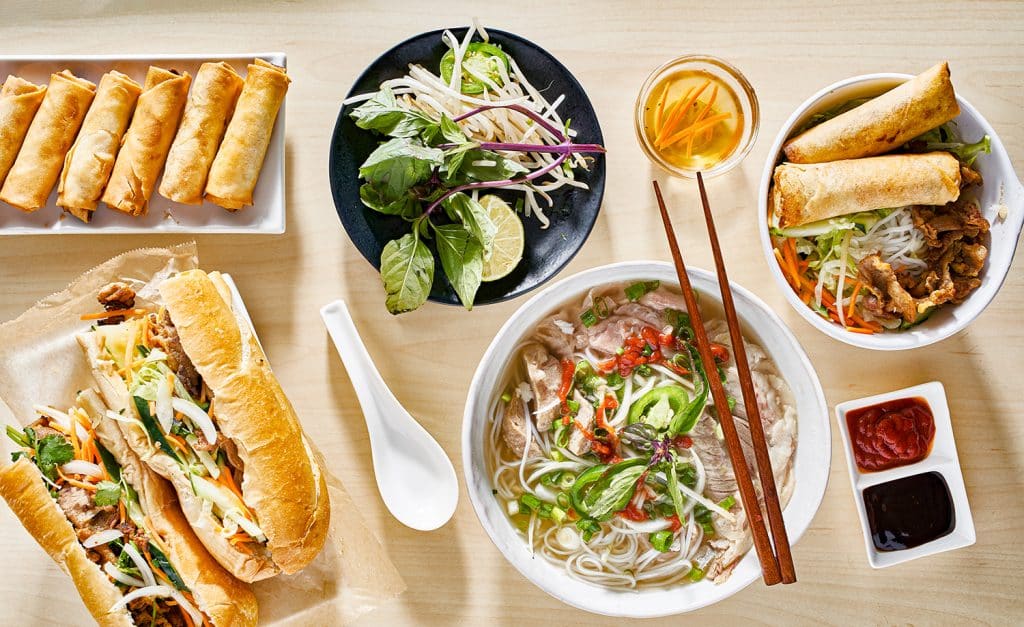 assorted vietnamese dishes with pho, bahn mi, spring rolls in top down composition